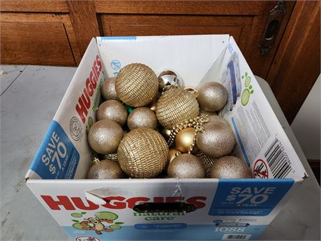 large box of gold christmas bulbs.