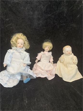 3 Porcelain Dolls Blond Hair Girls Blue Dress Pink Dress Baby In Yellow Dress